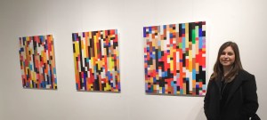 Amelia with works displayed at the Bondi Beach art show, NIGHT.